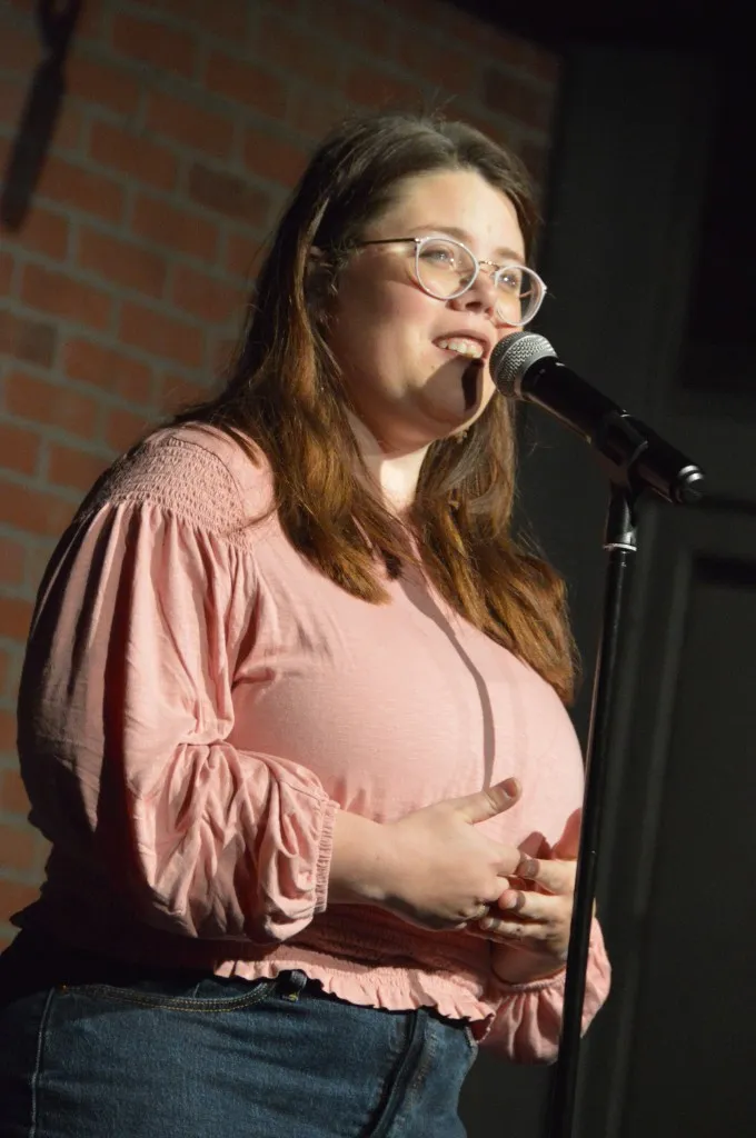 Becca Bailey speaking into a microphone on stage