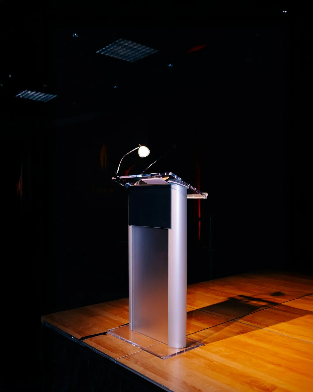 A modern podium with a microphone on a stage.